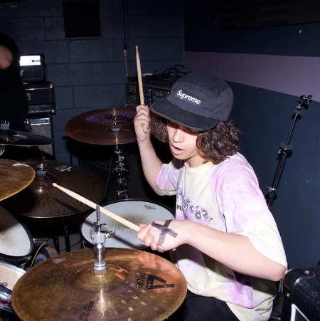 The musician Dante Melucci plays the drum.